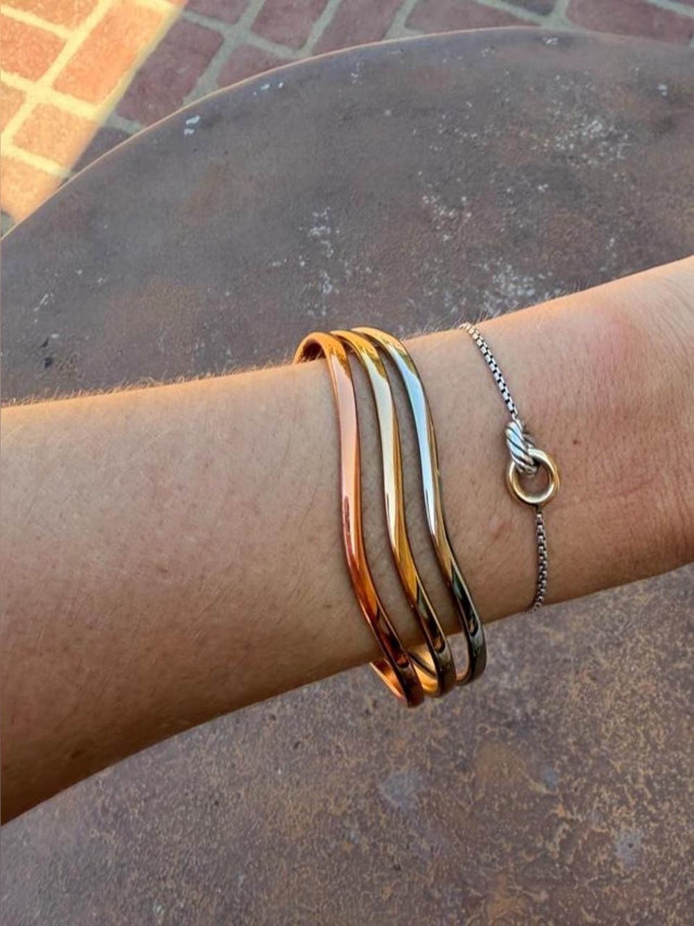 Multi-colored cuff bracelet with three stacked metallic bands in rose gold